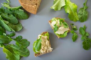 Sandwich with herring paste and greens on a gray background. Simple breakfast. photo