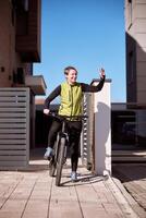 Woman Waving While Going Out Of The House With a Bicycle photo