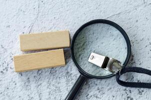 Magnifying glass and whistle with customizable space on wooden block for text photo