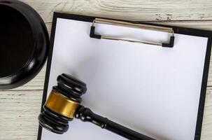Blank white paper clipboard with customizable space for text and with gavel next to it. Copy space concept photo