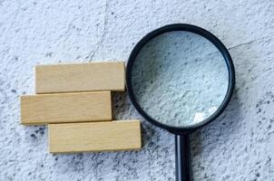 Magnifying glass with customizable space on wooden block for text. photo