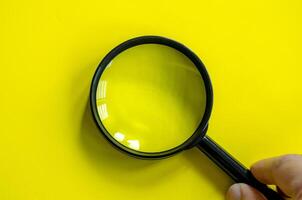 Hand holding a magnifying glass with customizable space for text. photo