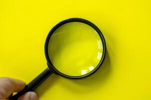 Hand holding a magnifying glass with customizable space for text or ideas. photo