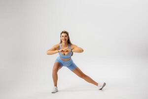 Fitness enthusiast performs a side lunge exercise in a studio setting during a workout session photo