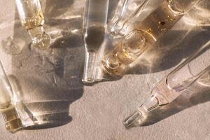 Close up of glass pipettes with moisturizing serum with colloidal gold. photo