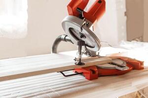 Circular saw in use cutting a wooden plank inside a workshop. The image highlights the precision and efficiency of the tool, emphasizing its role in woodworking projects and carpentry. photo