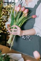 florist work on preparing beautiful floral arrangement. Various flowers and materials lie on table, emphasizing the artistic and inspiring atmosphere associated with floral photo