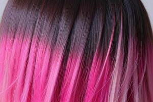 This close-up photo accentuates the vibrant allure of pink hair in an ombre design, revealing a harmonious fusion of colors and textures.