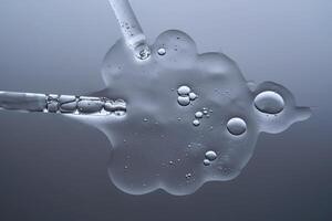 Two pipettes with a serum texture on a gray background. photo