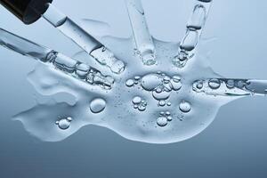 The serum flows from several pipettes into a single texture on a blue background. photo