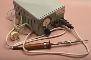 An old soldering iron with a silver tip photo