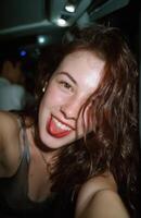 Young woman sticking out tongue and taking selfie on bus photo