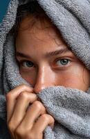 Young woman hiding her face with a towel after shower photo