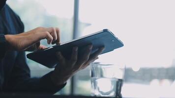 A person using a tablet computer with a glass of water video