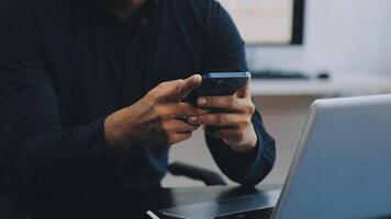 A man using his phone while sitting at a desk video