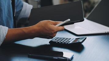Man using a tablet and calculator at his desk video