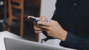 A man using his cell phone while sitting at a table video