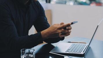 Man using his smartphone while sitting at a desk video