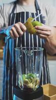 Man peal and add kiwo to Smoothie Strawberry Banana Goji Berry Refreshing and Nutritious video