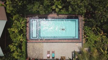 Top down view serene scene woman enjoying swim in private pool deep within Sri Lanka lush and isolated wilderness in topical forest. Tranquil retreat offer peace, natural beauty. Perfect escape. video