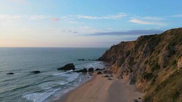 Adraga Beach and Cliffs at Sunset. Atlantic Ocean, Portugal. Aerial View. Moving Forward and Upwards video