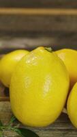 Vertical . Lemons with fresh leaves on rustic background video