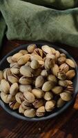 Vertical . Roasted pistachios nuts in bowl. Top view. video