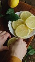 Vertical . Preparing sliced fresh lemons for summer lemonade. Top view. video