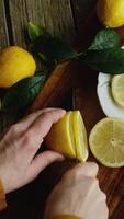 Vertical . Summer food. Lemon slicing. Hands cutting fresh lemons into slices. Top view. video