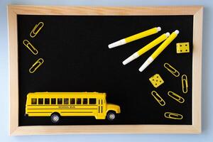 Minimalist school concept with blackboard yellow school bus markers paper clips and dice in monochrome color palette symbolizing back to school routine organization and educational visuals photo