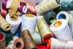 close up of various spools of threads of all colors used in the textile industry photo
