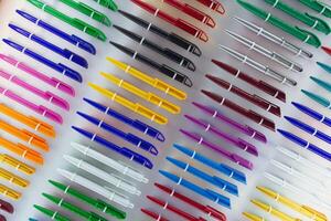Multicolored plastic writing pens on the counter photo