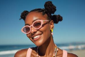 A smiling woman with tightly twisted hair buns poses against a sunny beach backdrop. photo