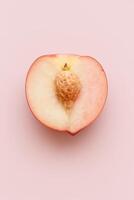 Close-up of a single half of a white peach with visible pit, placed flat on a soft pastel pink background, high-key studio lighting, minimal shadows, clean and modern aesthetic photo