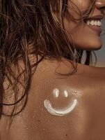 Close-up of a tanned back with a playful smiley face drawn using white sunscreen. Hair is slightly wet, and the skin glows in the sun. photo