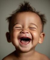 A joyful baby laughing with eyes closed, showing tiny baby teeth and deep dimples on the cheeks. photo