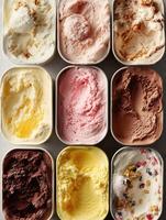 Top-down photo of various ice cream tubs in different flavors vanilla, strawberry, lemon, chocolate, nut, and berry.