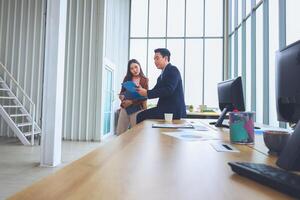 Two business professionals discussing documents in modern office, Team meeting and brainstorming concepts photo