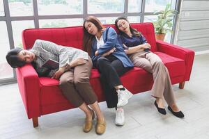 Tired Businesswomen Sleeping on Office Couch, Exhausted Coworkers Taking a Nap During Workday, Colleagues Resting on Sofa photo