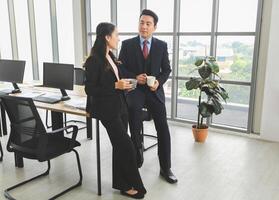 Business Colleagues Enjoying Coffee Break in Modern Office, Professional Team Chatting During Work Break, Friendly Conversation Between Coworkers in Office Setting photo