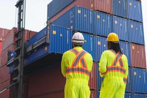 Engineer man Team in Safety Gear Control Containers Box at Container Cargo, Container Yard Workers and Foreman Team Discussion at Shipping Yard photo