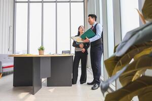 Two Business Professionals Discussing Documents in Modern Office Environment photo