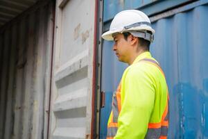 Engineer man checking containers box in in industry containers yard, Dock worker inspecting containers box photo
