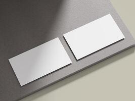 Business card mockup positioned on a light grey cement block with clean lines, suitable for showcasing corporate identity. photo