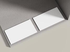A business card mockup resting on a light neutral cement surface with minimal shadows, ideal for clean and simple designs. photo
