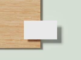Minimalist white business card resting on a wooden surface with a subtle shadow, creating a clean and professional look. photo
