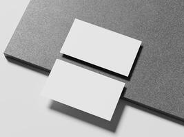 A pair of simple white business cards positioned on a smooth marble surface, casting a subtle shadow for an elegant presentation. photo