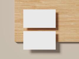 Two white business cards stacked on a wooden table with a soft shadow, showcasing a simple and elegant design. photo