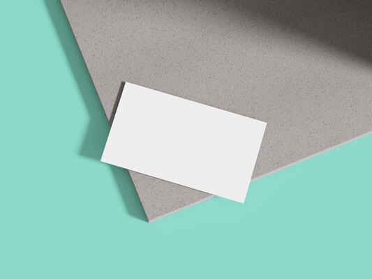 A clean and minimalistic business card mockup resting on a textured cement block, perfect for showcasing modern brand designs.