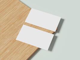 Two white business cards displayed on a wooden table, featuring subtle shadows and a minimalist style perfect for branding. photo